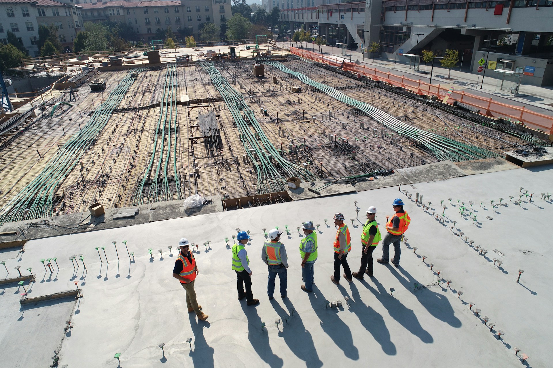 Construction workers in hi-vis inspecting a large building site